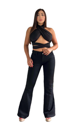 Woman wearing a black top and black jeans standing in a living room.